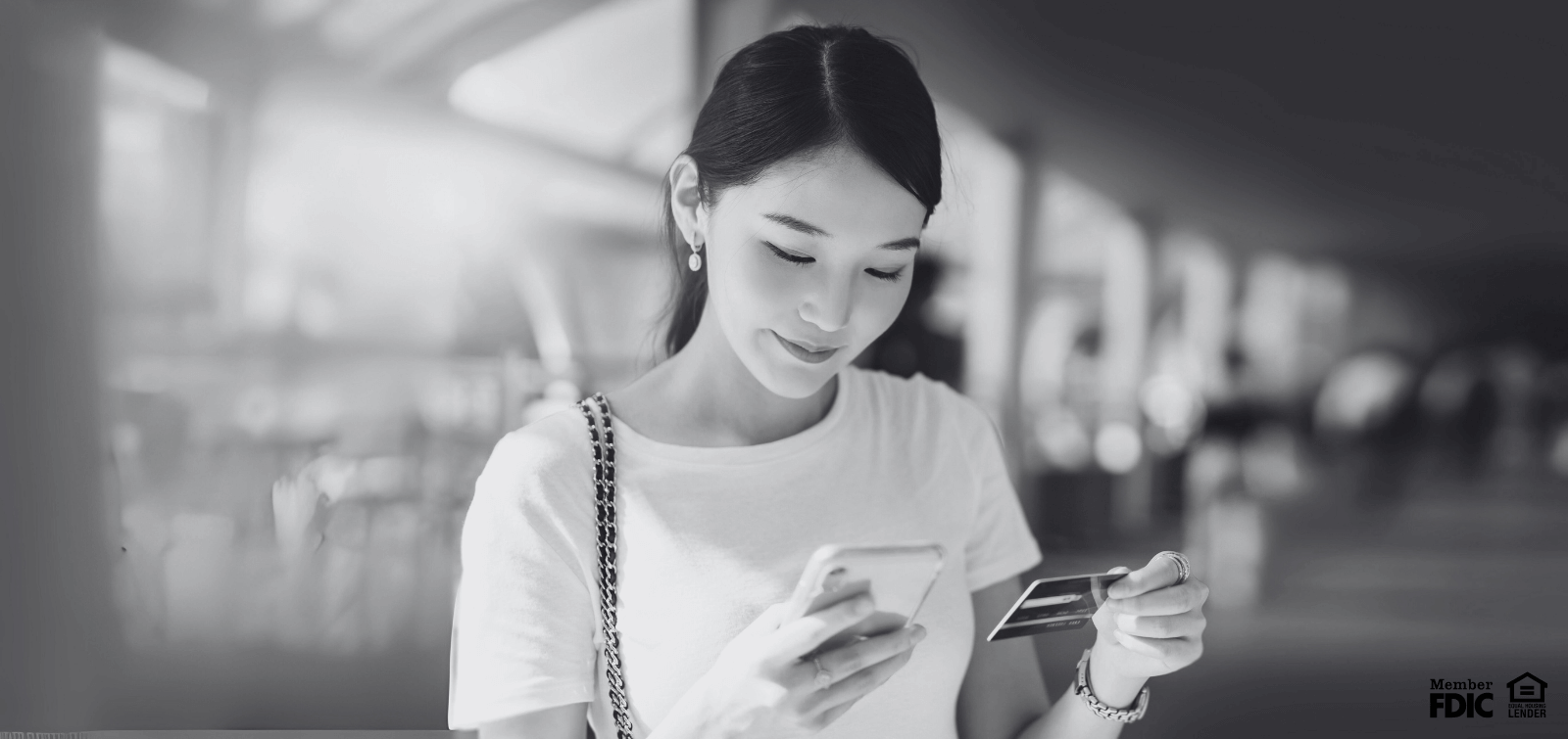 a young woman checks her credit card balance on her phone