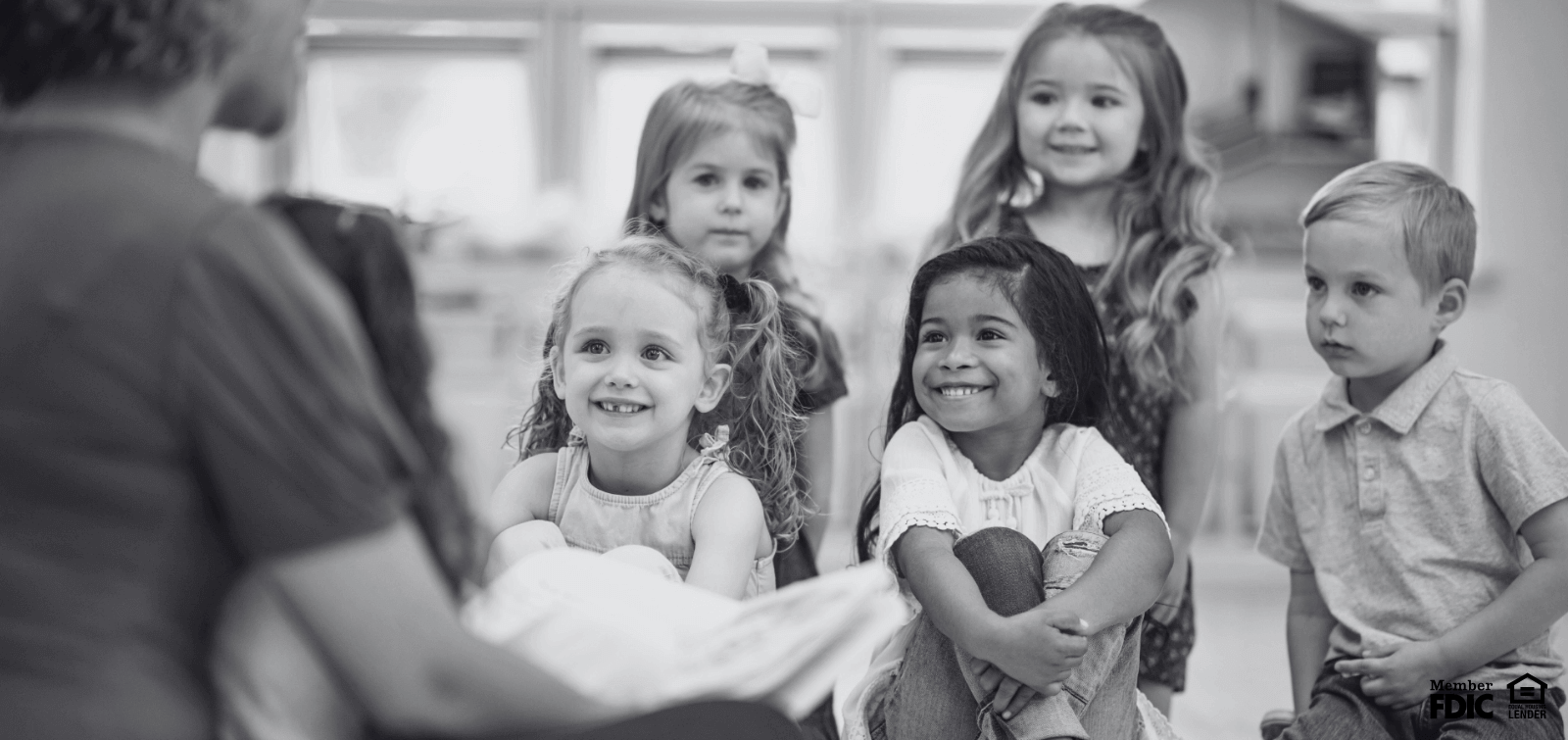 a group of children enjoy story time at daycare 