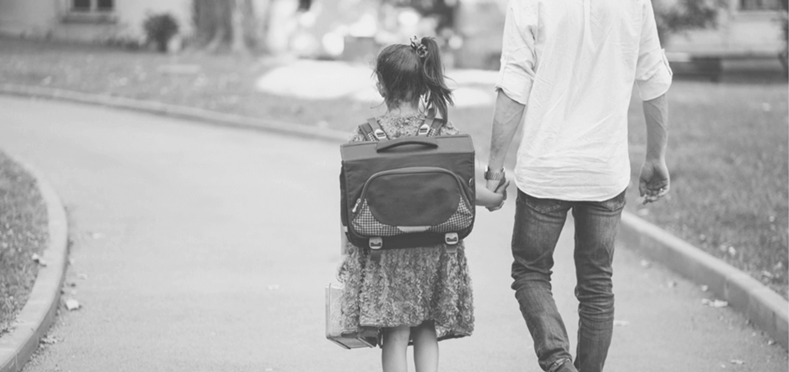 a parent walks their daughter to bus on her first day back to school