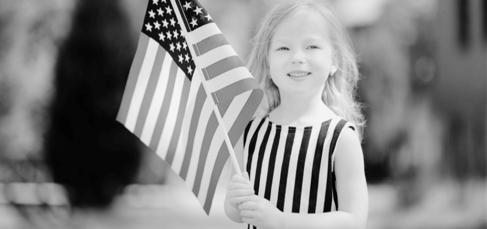 a young girl holds an American flag in her hands