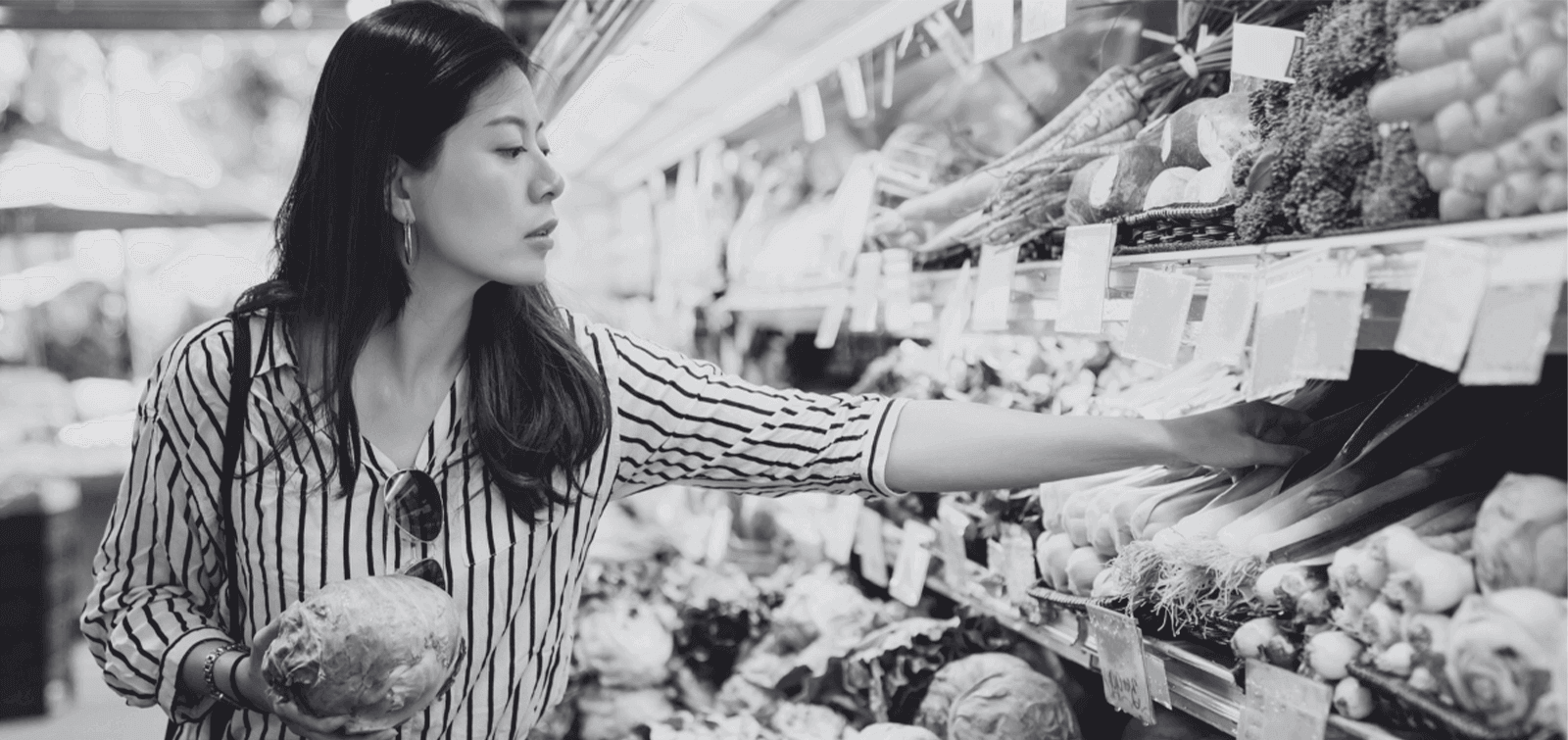 a woman shops for vegetables in a grocery store