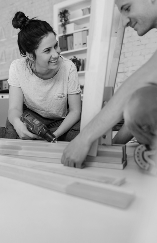 Woman smiling while working in carpentry as she builds something