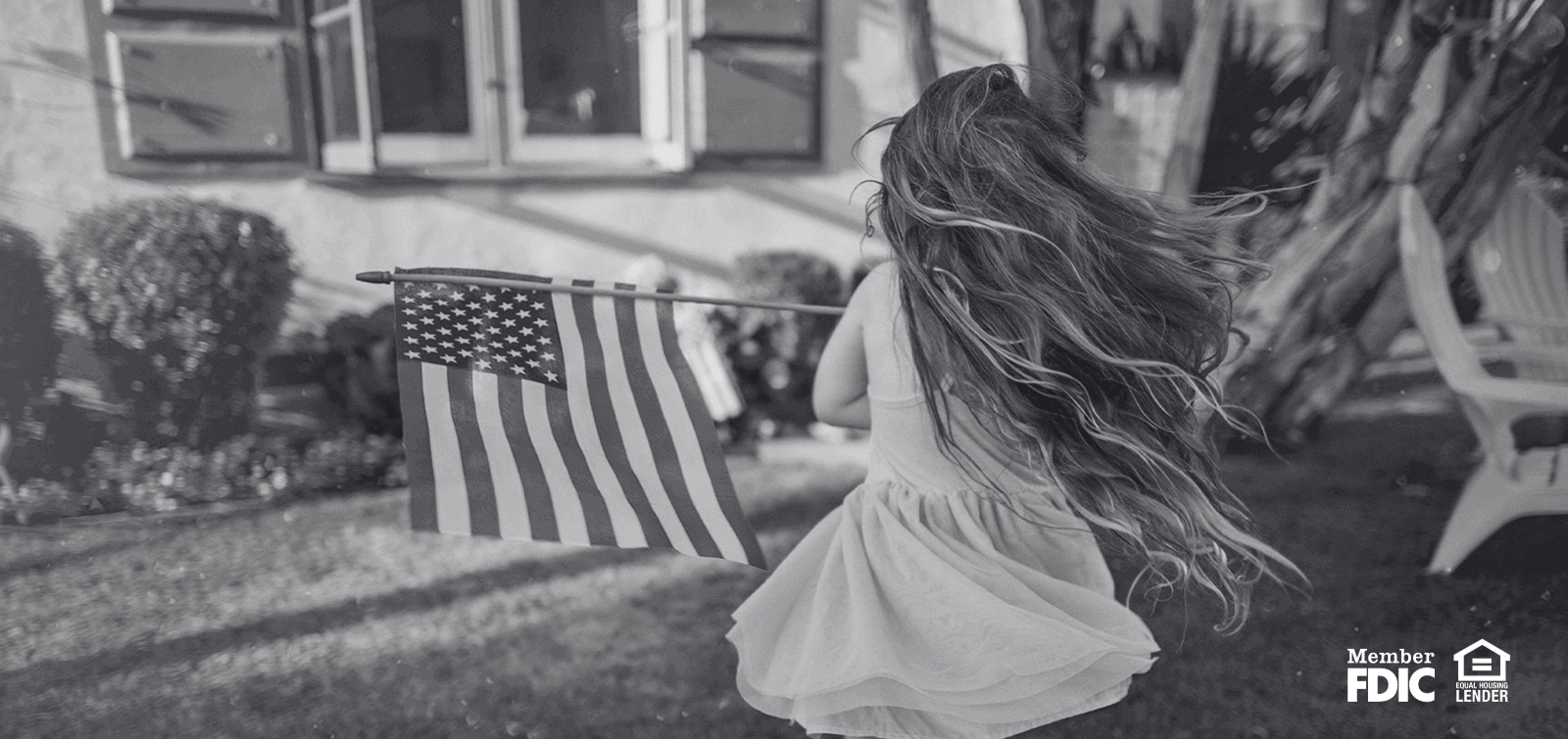 a young girl spins around in circles with an American Flag.