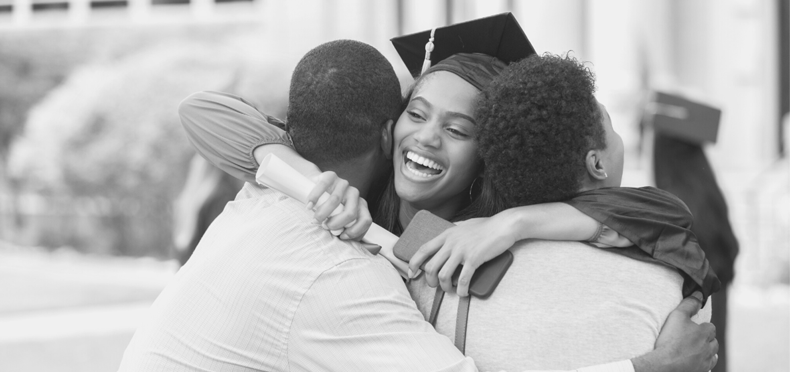 a high school graduate hugs her friends after opening the financial gift they gave her